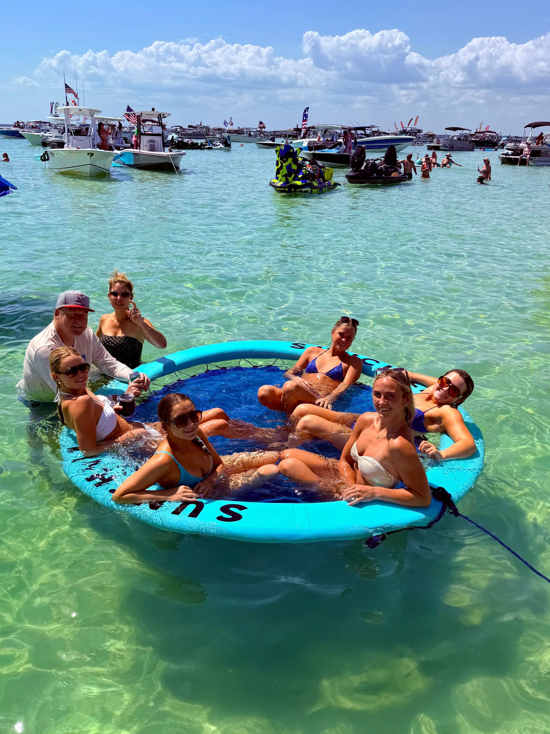 Family relaxing together on the Sunchill floating raft in emerald Destin water