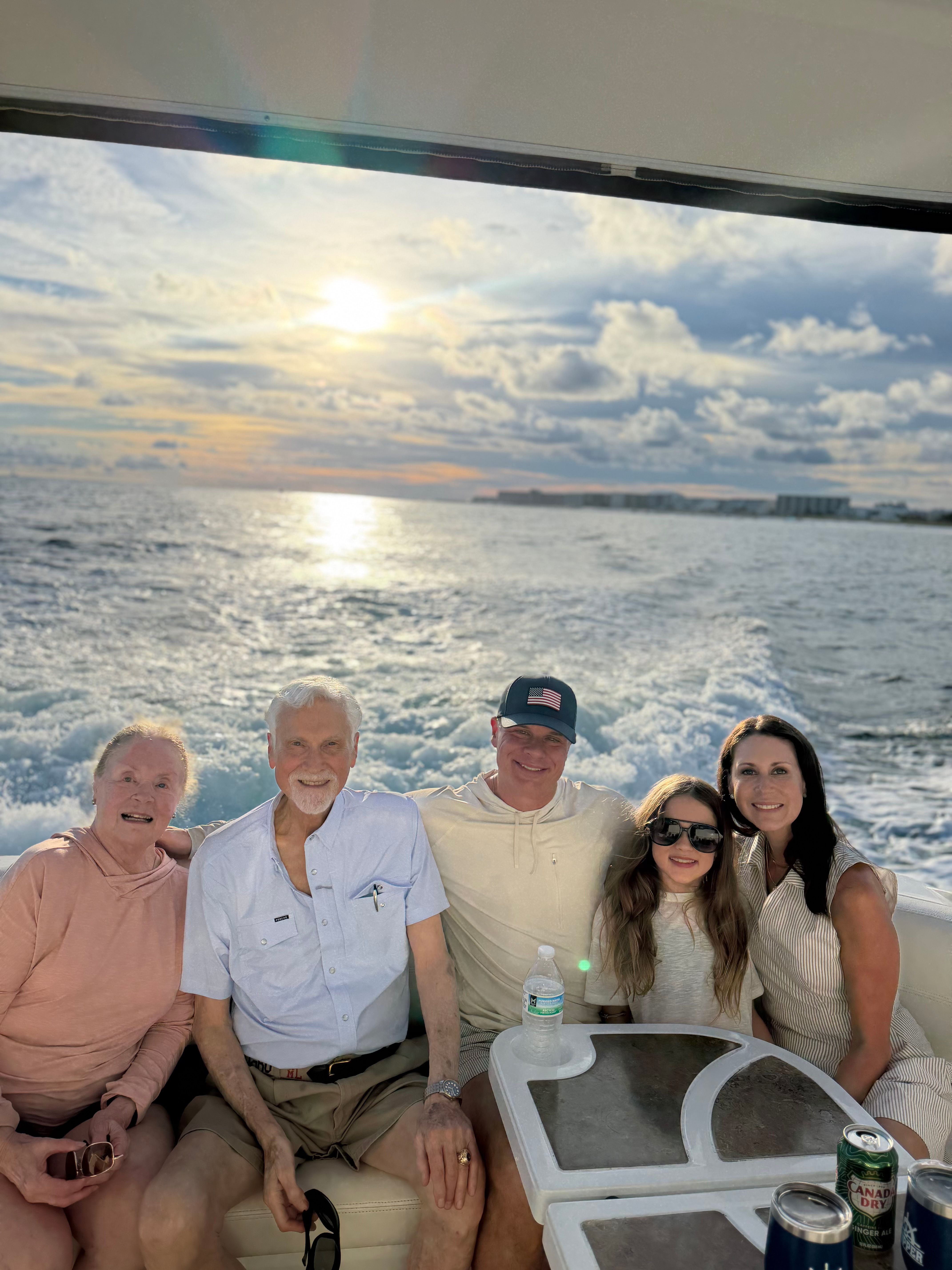 Family seated together at the stern of the Miss B Haven with the sun over the water